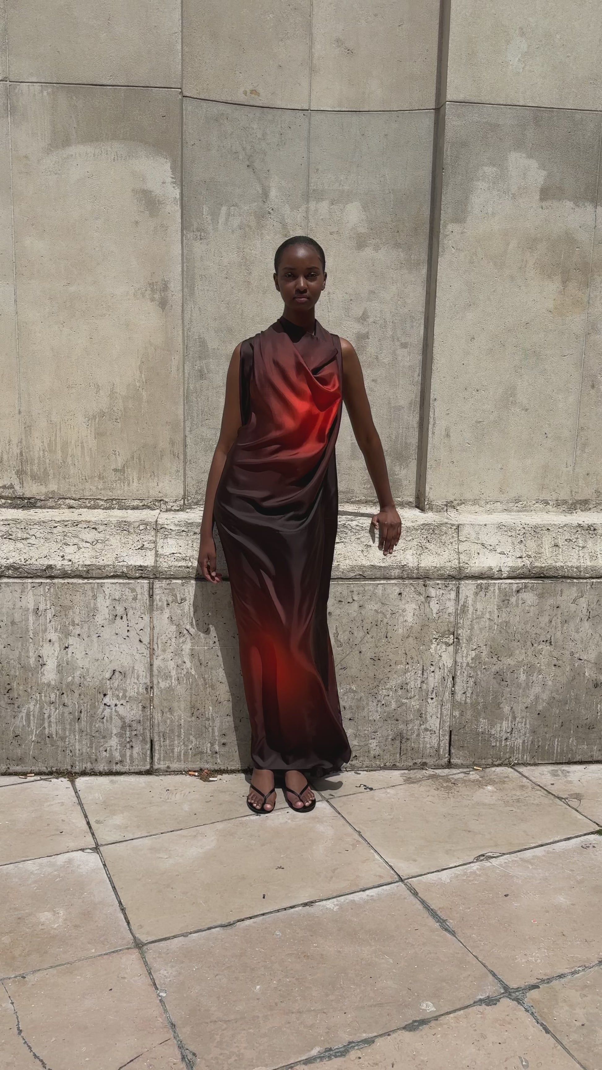 Female model against a stone wall wearing APAR Edition 002 - carre sleeveless dress in red printed silk twill