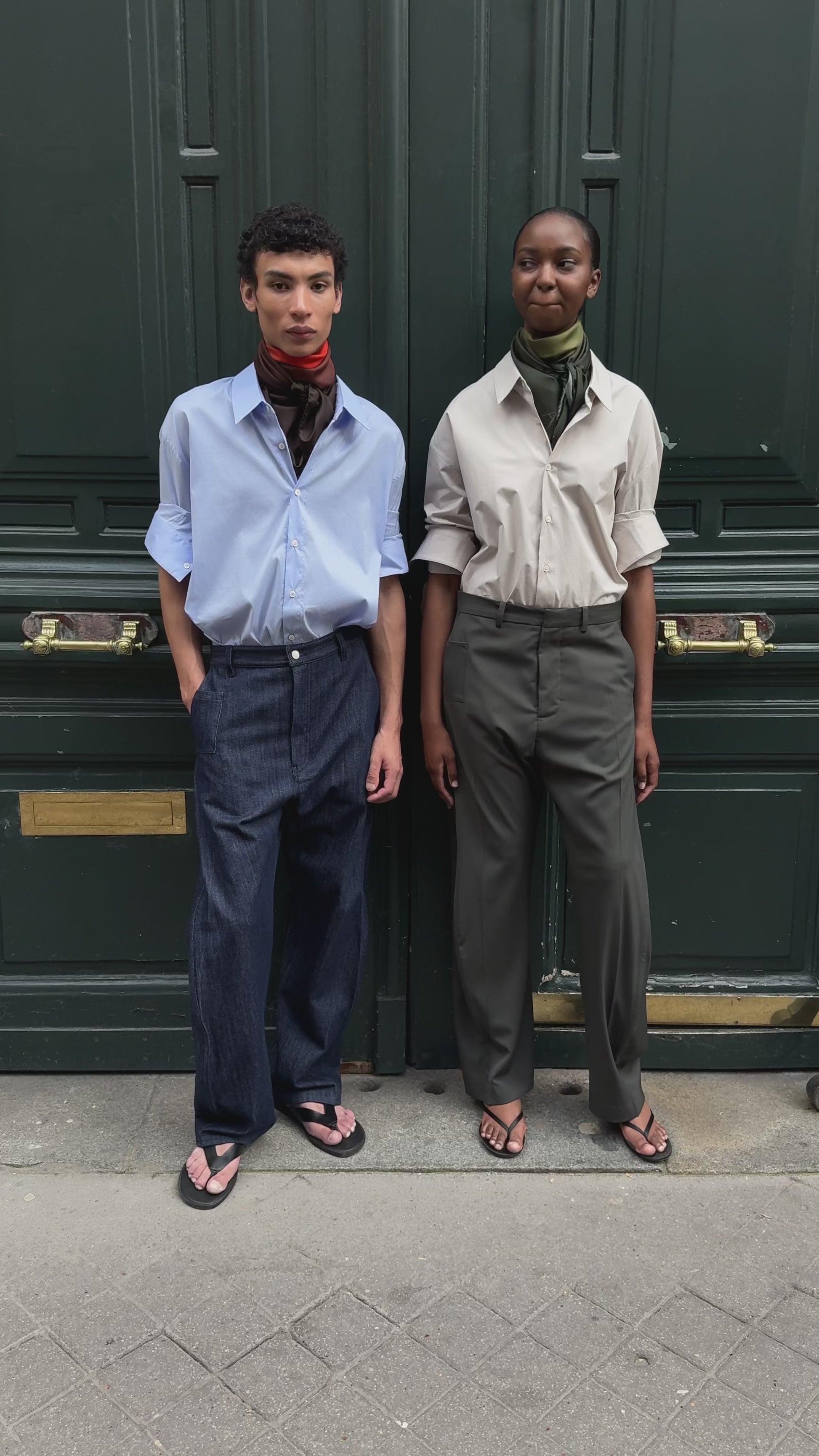 Male & female model in front of a large Parisian green door wearing APAR edition 002 - oversized shirt, carre 90 printed scarf and twisted leg trouser